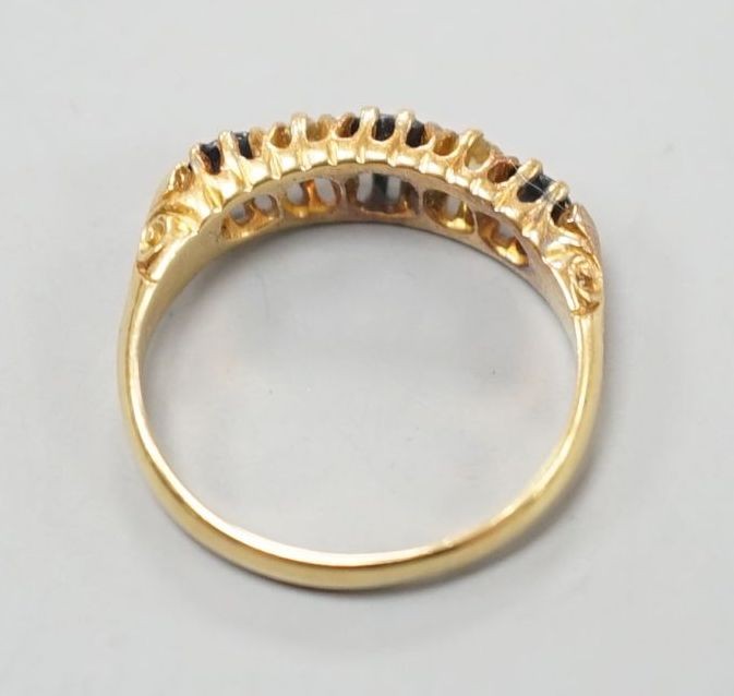 A George V 18ct gold, three stone sapphire and two diamond set half hoop ring, size M, gross 3.1 grams.